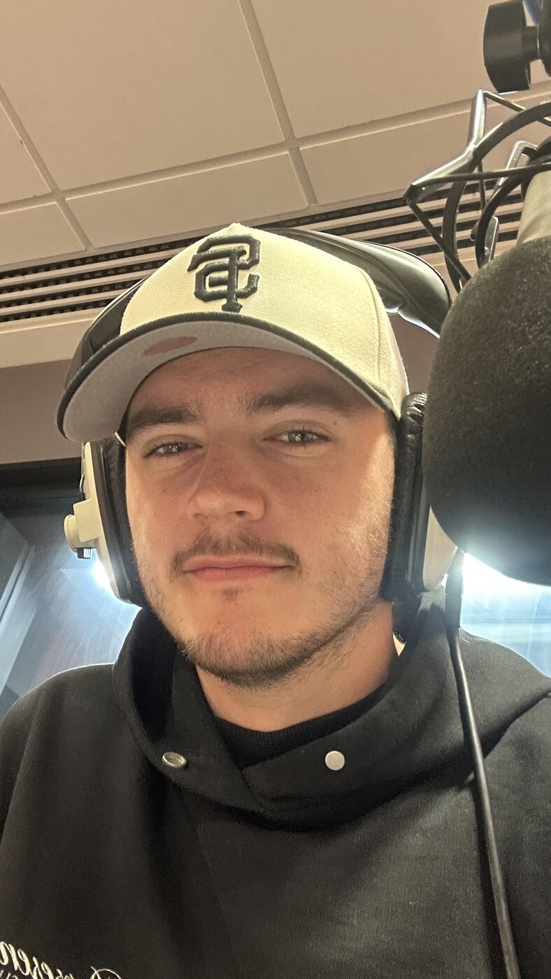 Matt on the radio, headphones on, at the mic